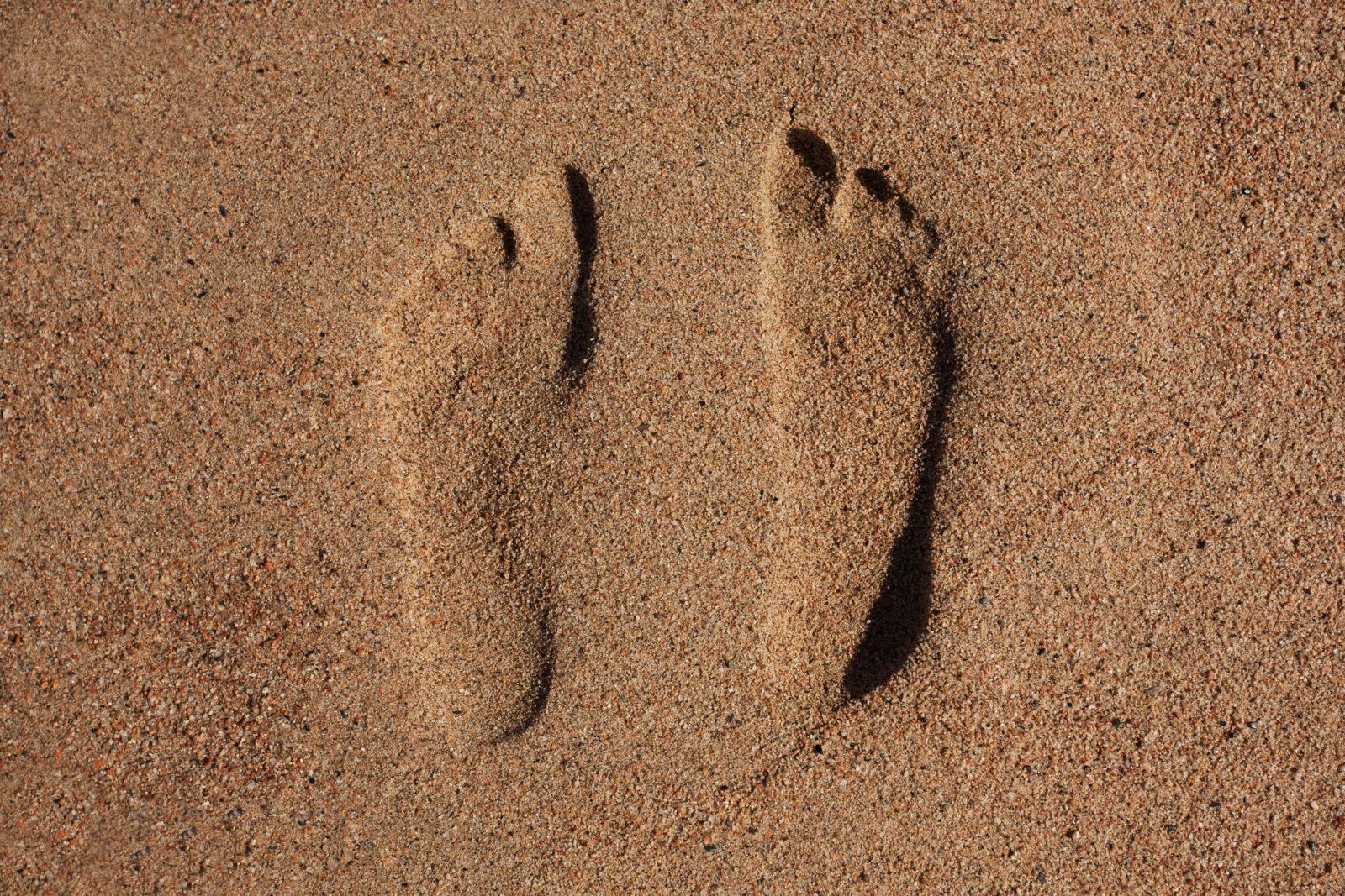 Следы ног человека. Плоскостопие след на песке. Traces of bare feet on the Sand. Traces of bare feet on the Sand of a man.